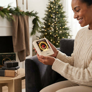 A person holding the magnetic vinyl record player in a cozy, warmly lit living room to represent a satisfaction guarantee.